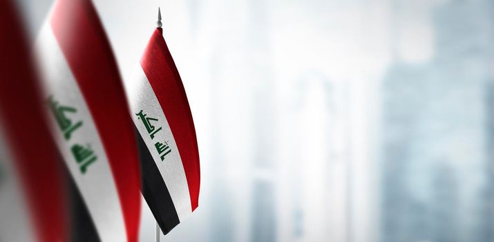 Small flags of Iraq on a blurry background of the city.