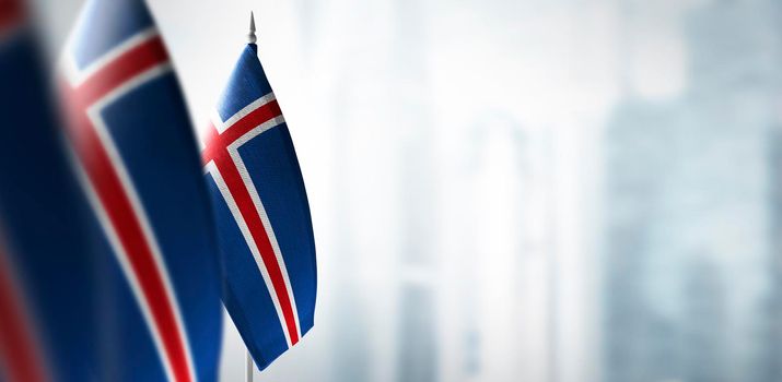 Small flags of Iceland on a blurry background of the city.