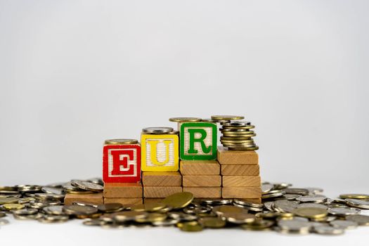 Forex EUR concept with wooden blocks and coins. Forx EUR letters on wooden blocks sorrounded with money