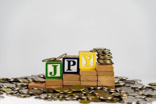 Forex JPY concept with wooden blocks and coins. Forx JPY letters on wooden blocks sorrounded with money
