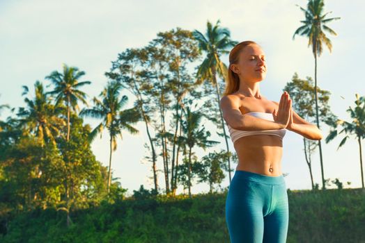 Young woman practicing yoga - greeting the sun at sunrise