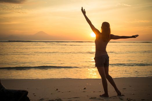 Young woman watching as sun sets over Pacific Ocean