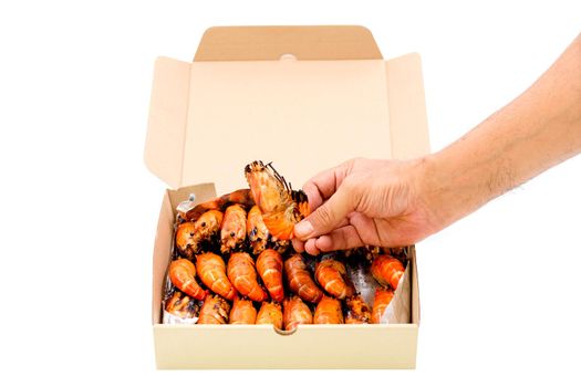 Close up a human hand pick up a grilled river prawn in a paper box isolated on white background.