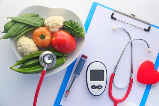 diabetic measurement tools and fresh vegetable on table .