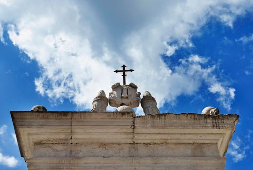 Montecassino-Italy-August 29 -2021 Cloister of  Bramante detail of entablature with cross againt cloudy sky in Montecassino Abbey 