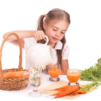 Nice blond baby girl with glass of carrot juice