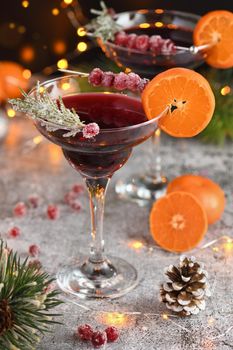 Goblet with cranberry Margarita with candied cranberries, rosemary and tangerine. Perfect cocktail for a Christmas party