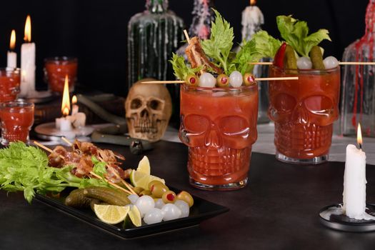 Creepy Halloween party. Michelada the Mexican Bloody Mary. Prepared with tomato juice, tequila, hot sauce, served with ice in a beer glass with bacon garnished with celery, olive, and pickled onions