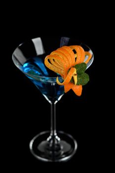 Decoration for a cocktail of orange and mint. Elegant and original presentation. Martini Blue Curacao on a black background