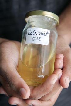 man hand hold a jar of coconut oil .