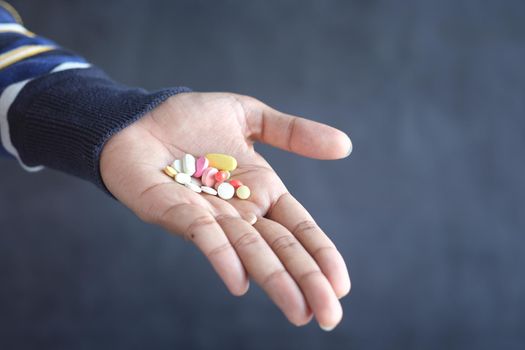 man's hand with pills spilled out of the container .