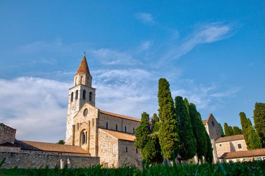 Panoramic view of the Basilica of Santa Maria Assunta in Aquileia. It is located on Via Sacra, overlooking the Piazza del Capitolo, along with the bell tower and baptistery. Italy