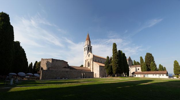 Panoramic view of the Basilica of Santa Maria Assunta in Aquileia. It is located on Via Sacra, overlooking the Piazza del Capitolo, along with the bell tower and baptistery. Italy