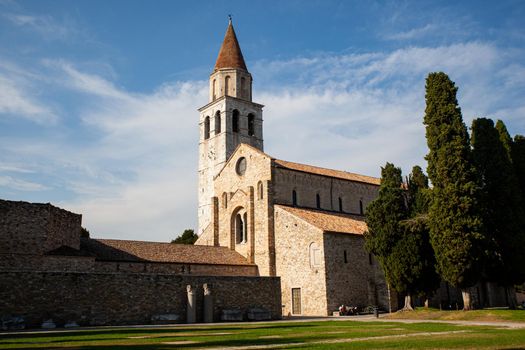 Panoramic view of the Basilica of Santa Maria Assunta in Aquileia. It is located on Via Sacra, overlooking the Piazza del Capitolo, along with the bell tower and baptistery. Italy