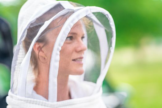 woman beekeeper in protective suit in beekeeping.