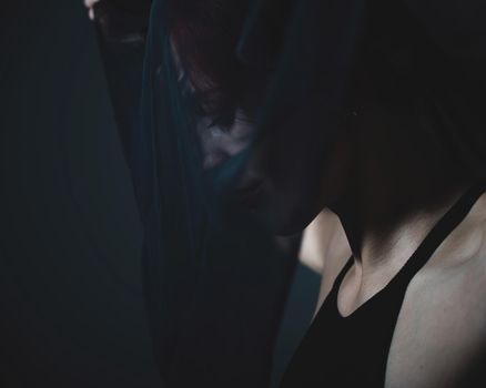 Profile of a woman in a black veil. Costume Dead bride for Halloween. Portrait of an evil grinning Witch in front of a coven