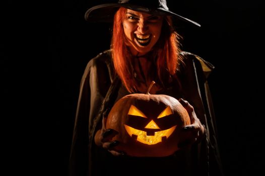 Wicked witch holding a jack-o-lantern for halloween.