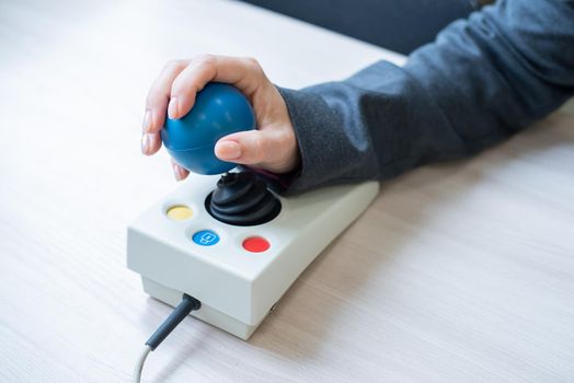 Woman with cerebral palsy works on a specialized computer mouse