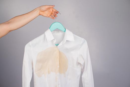 Women's office white shirt with a stain of coffee on a white background