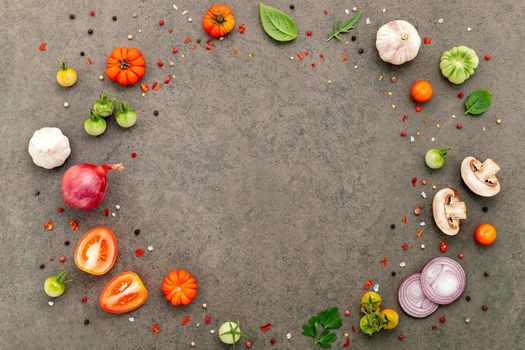 The ingredients for homemade pizza set up on dark stone background.