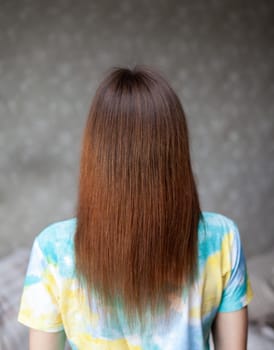 A girl with long, straight and beautiful brown hair. Hair care at home.