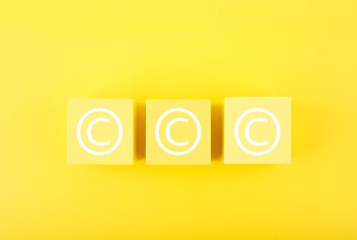 Minimal trendy copyright, intellectual property and patenting concept. Copyright symbol on yellow cubes against bright yellow background