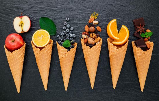 Various of ingredient for ice cream flavor in cones set up on dark stone background . Summer and Sweet menu concept.