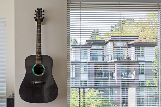 Living room window with guitar on the wall.