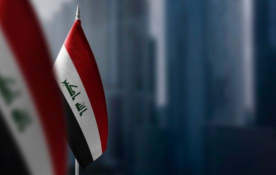 Small flags of Iraq on a blurry background of the city.