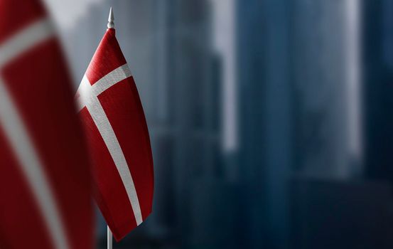 Small flags of Denmark on a blurry background of the city.