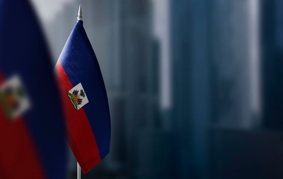 Small flags of Haiti on a blurry background of the city.