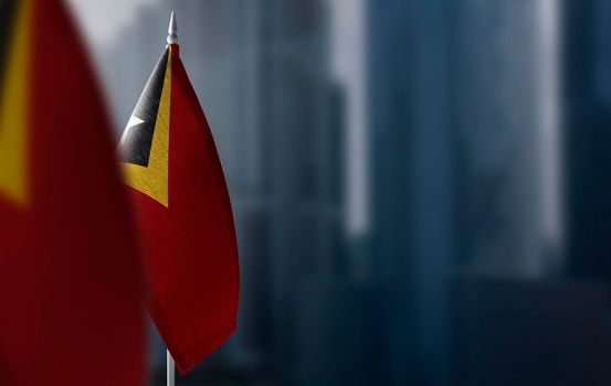 Small flags of East Timor on a blurry background of the city.