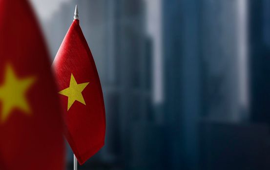 Small flags of Vietnam on a blurry background of the city.