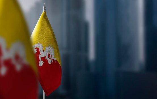 Small flags of Bhutan on a blurry background of the city.