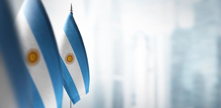 Small flags of Argentina on a blurry background of the city.