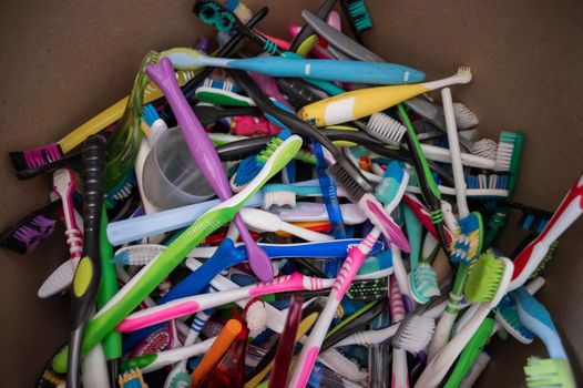 A close-up of many used plastic toothbrushes collected for recycling
