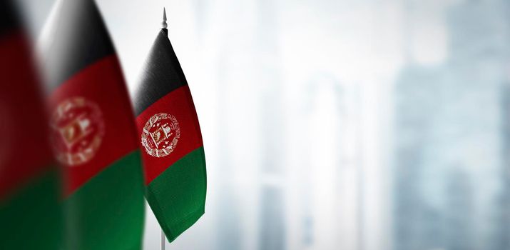 Small flags of Afghanistan on a blurry background of the city.