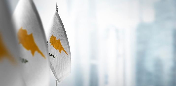 Small flags of Cyprus on a blurry background of the city.
