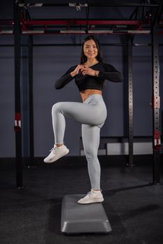 Asian woman doing platform exercises in the gym.