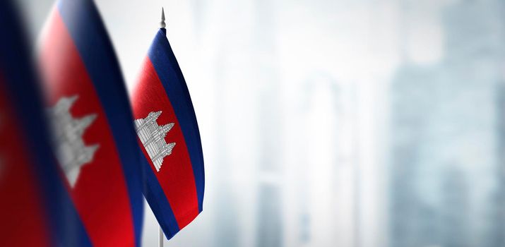 Small flags of Cambodia on a blurry background of the city.