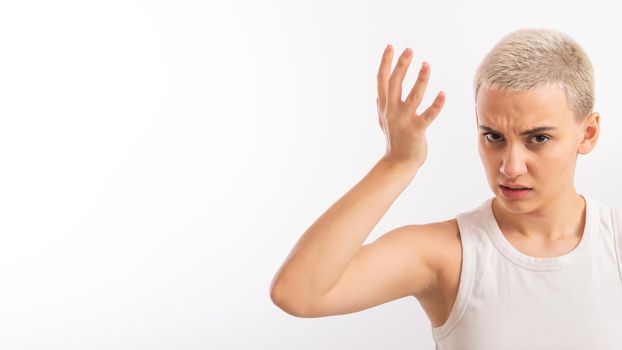 Young caucasian woman with short hair with a palm on her face on a white background