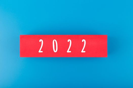2022 numbers written on red rectangle in the middle of blue background. Minimal elegant concept of New 2022 Year 