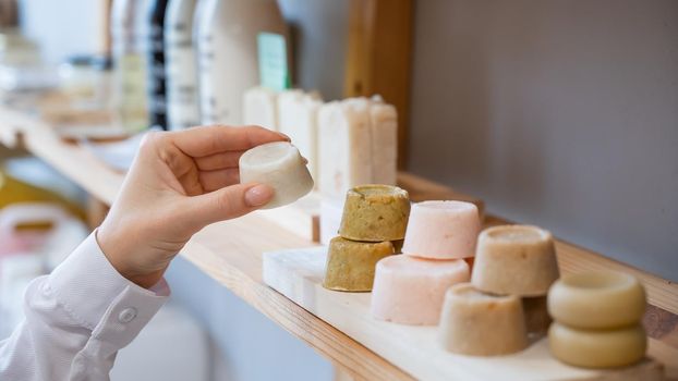 Woman chooses organic soap in eco friendly store
