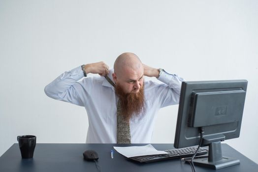 Problems for the office worker. A bald man in a white shirt sits at a desk with a computer and is stressed because of failure. A nervous breakdown