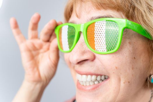 Portrait of smiling elderly woman wearing glasses with ireland flag