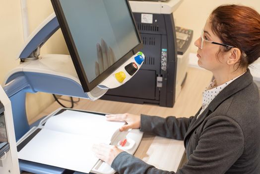 A visually impaired woman uses special reading equipment.