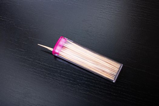 Toothpicks in a plastic box on a wooden table