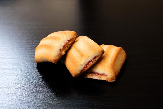 Three square biscuit cookies on a wooden table