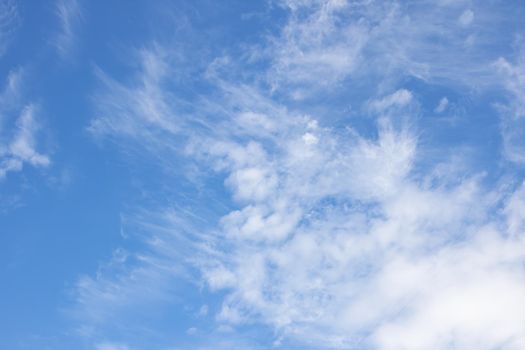 White cirrus clouds in the blue sky close up