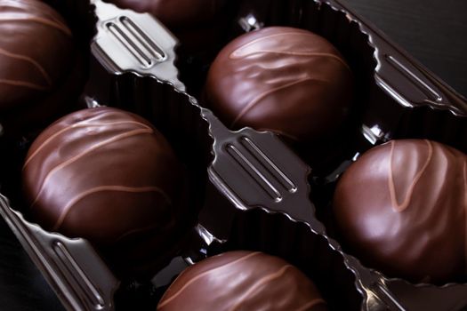 Chocolate candies in a box close up, macro photo